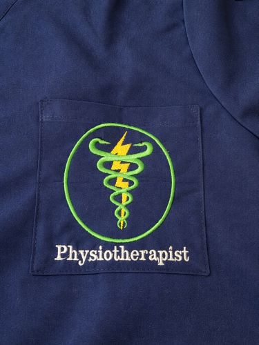 Physiotherapist tunic – A customised navy blue medical tunic featuring an embroidered physiotherapy emblem on the chest pocket, carefully finished with enhanced detailing and vibrant colours.