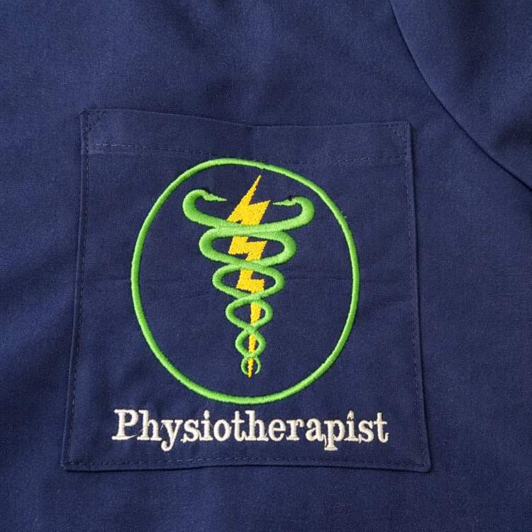 Physiotherapist tunic – A customised navy blue medical tunic featuring an embroidered physiotherapy emblem on the chest pocket, carefully finished with enhanced detailing and vibrant colours.