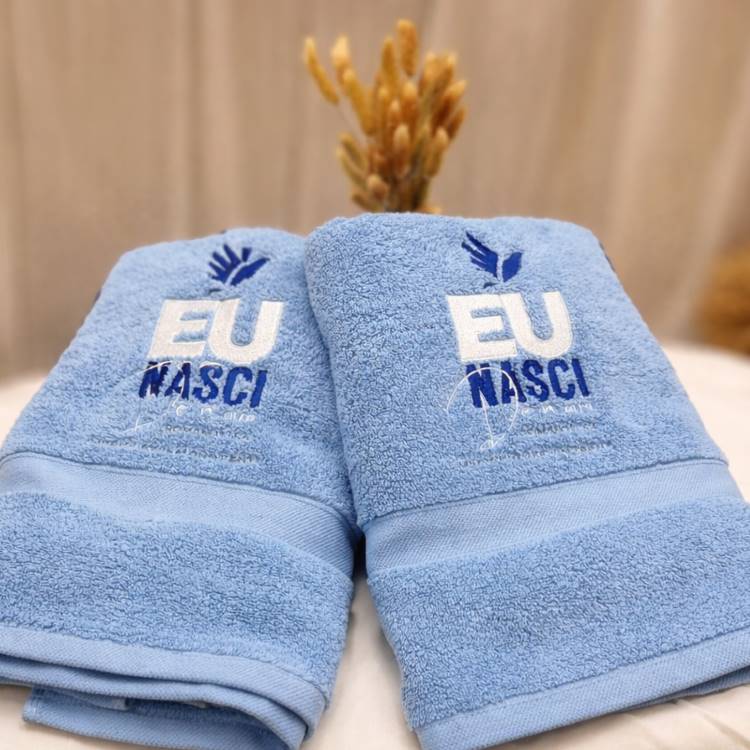 Embroidered towels – A pair of customised light blue towels featuring “EU NASCI” embroidery, carefully crafted with soft texture and enhanced colour detail.